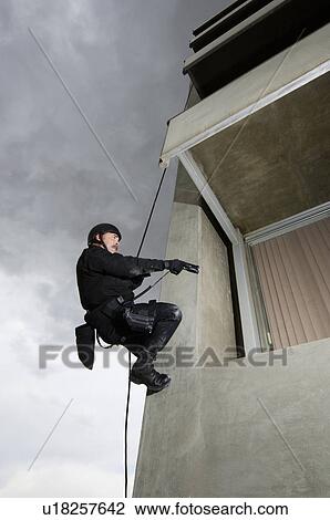 SWAT Team Officer Rappelling and Aiming Gun View Large Photo Image Stock Image - SWAT Team Officer Rappelling and Aiming Gun. Fotosearch