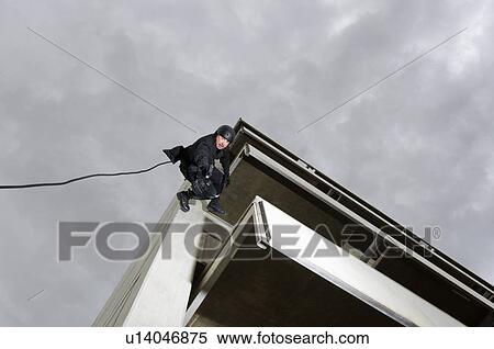 SWAT Team Officer Rappelling and Aiming Gun View Large Photo Image Stock Photography - SWAT Team Officer Rappelling and Aiming Gun. Fotosearch