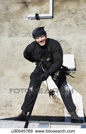 SWAT Team Officer Rappelling from Building View Large Photo Image Stock Photo - SWAT Team Officer Rappelling from Building. Fotosearch