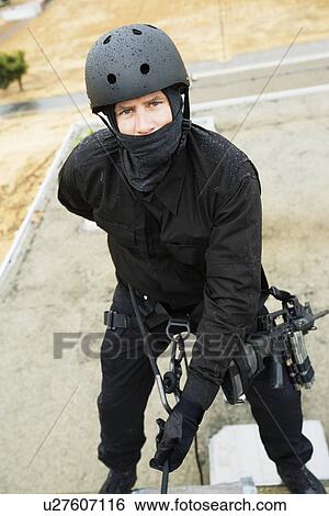 Stock Photograph - SWAT Team Officer Rappelling from Building. Fotosearch