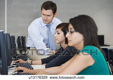 Teacher Helping Computer Students View Large Photo Image Stock Photo - Teacher Helping Computer Students. Fotosearch