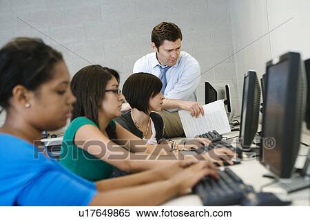 Stock Photography - Teacher Helping Student in Computer Lab. Fotosearch