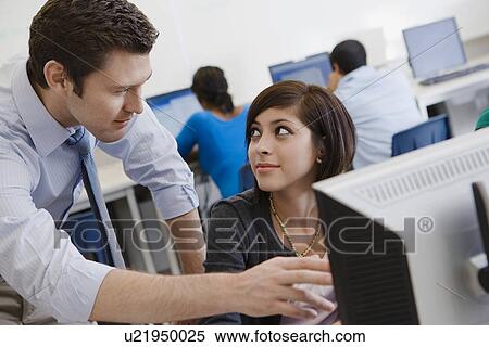 Stock Photography - Teacher Helping Student in Computer Lab. Fotosearch