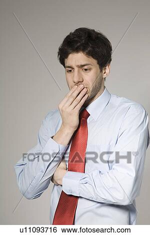 Stock Photograph - Thoughtful young man, studio shot. Fotosearch