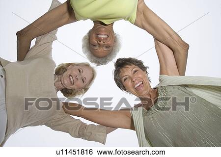Stock Photograph - Three senior women look down at camera. Fotosearch