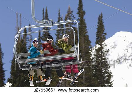 Stock Photo - Three Skiers on Chair Lift. Fotosearch