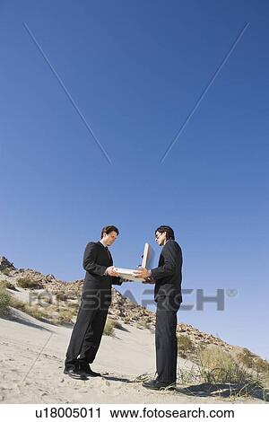 Two Businessmen Holding Open Briefcase in the Desert View Large Photo Image Stock Image - Two Businessmen Holding Open Briefcase in the Desert. Fotosearch