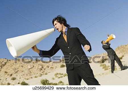 Stock Photo - Two Businessmen Using Megaphones in Desert. Fotosearch