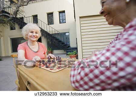 Stock Image - Two senior men playing chess. Fotosearch