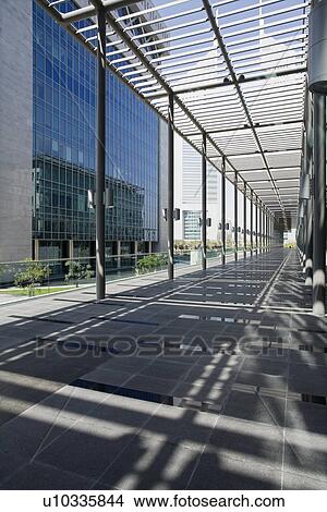 Picture - UAE, Dubai, architectural detail of a long outdoor hallway at the Dubai International Financial Centre. Fotosearch