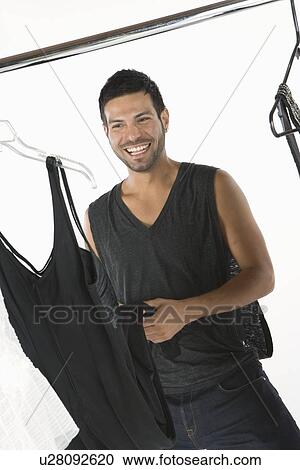 Wardobe stylist stands with clothes rail smiling View Large Photo Image Stock Image - Wardobe stylist stands with clothes rail smiling. Fotosearch