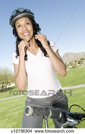 Woman adjust cycling helmet View Large Photo Image Picture - Woman adjust cycling helmet. Fotosearch