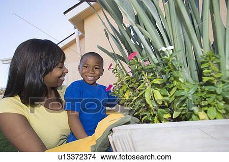Woman and son tending plants View Large Photo Image Picture - Woman and son tending plants. Fotosearch