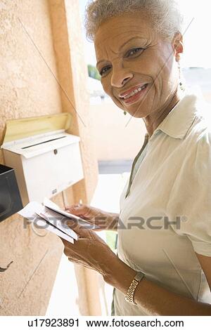 Woman collecting mail from letterbox View Large Photo Image Stock Image - Woman collecting mail from letterbox. Fotosearch