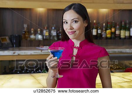 Stock Photography - Woman Drinking a Blue Martini. Fotosearch