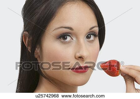 Stock Photo - Woman eating strawberry. Fotosearch