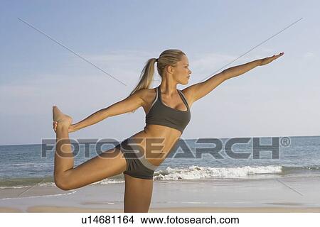 Picture - Woman exercising at beach. Fotosearch