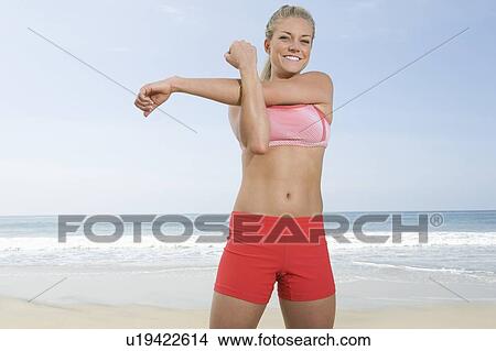 Picture - Woman exercising at beach. Fotosearch