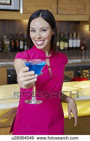 Stock Photo - Woman Holding out a Blue Martini. Fotosearch