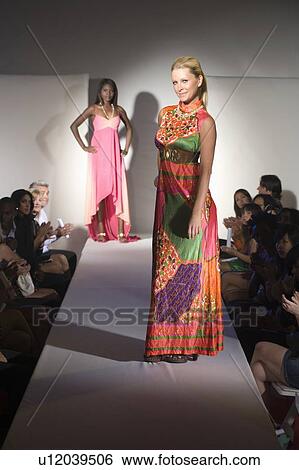 Stock Photograph - Woman in multicoloured dress on fashion catwalk. Fotosearch