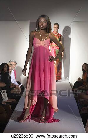 Stock Image - Woman in pink dress on fashion catwalk. Fotosearch