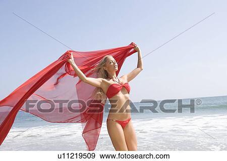 Stock Photo - Woman in red bikini holding red scarf. Fotosearch