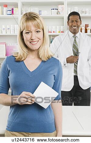 Stock Photograph - Woman picking up prescription drugs at pharmacy. Fotosearch