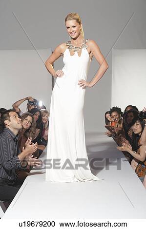 Woman stands in bridalwear on fashion catwalk View Large Photo Image Stock Image - Woman stands in bridalwear on fashion catwalk. Fotosearch