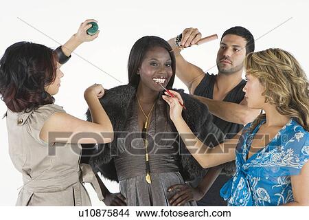 Picture - Woman stands in fur jacket with stylists on hand. Fotosearch