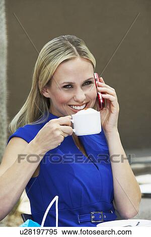 Stock Photography - Woman Talking on a Cell Phone in a Coffee Shop. Fotosearch