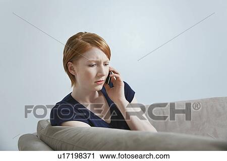 Woman talking on mobile phone on sofa View Large Photo Image Stock Image - Woman talking on mobile phone on sofa. Fotosearch