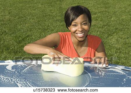 Stock Image - Woman washing car, high angle. Fotosearch