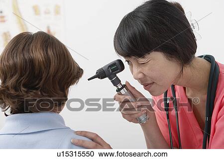 Young female doctor examining boy View Large Photo Image Stock Image - Young female doctor examining boy. Fotosearch