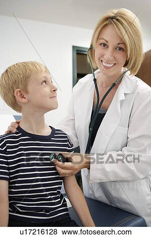 Stock Photo - Young female doctor examining boy. Fotosearch