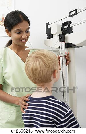 Young female nurse measuring boy's height View Large Photo Image Stock Photography - Young female nurse measuring boy's height. Fotosearch