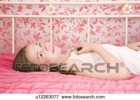 Stock Photo - Young girl lying on bed. Fotosearch