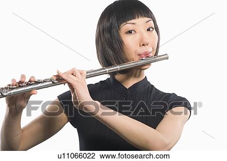 Stock Image - Young Korean woman playing flute. Fotosearch
