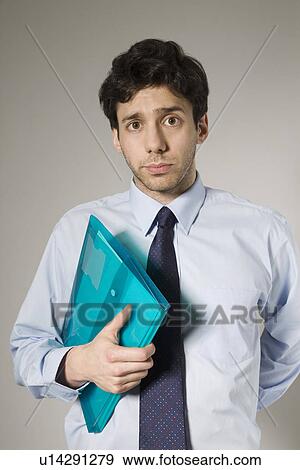 Young man holding documents View Large Photo Image Stock Photo - Young man holding documents. Fotosearch