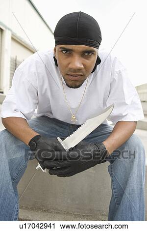 Stock Image - Young man posing with knife. Fotosearch