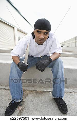 Stock Image - Young man posing with knife. Fotosearch