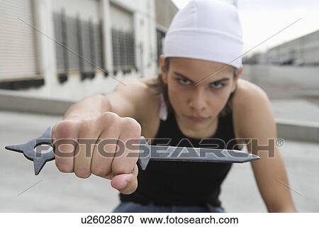 Stock Image - Young man posing with knife. Fotosearch