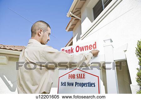 Young man putting up 'for sale notice' View Large Photo Image Stock Photography - Young man putting up 'for sale notice'. Fotosearch