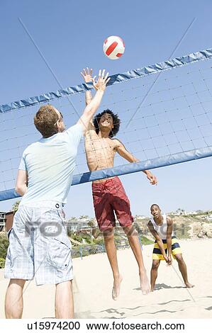 Young men playing beach volleyball View Large Photo Image Stock Image - Young men playing beach volleyball. Fotosearch