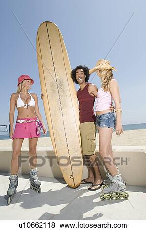 Stock Photo - Young people with surfboard. Fotosearch