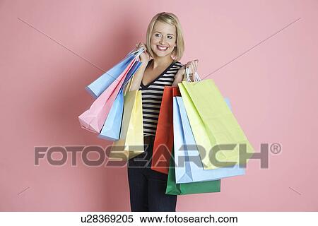 Young woman holding shopping bags and smiling View Large Photo Image Stock Photography - Young woman holding shopping bags and smiling. Fotosearch
