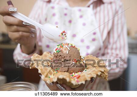 Stock Photo - Young woman preparing ice cream. Fotosearch