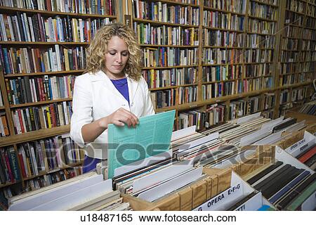 Stock Photography - Young woman shopping in music shop. Fotosearch