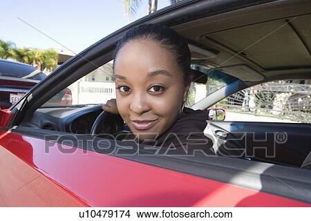 Picture - Young woman sitting in car. Fotosearch