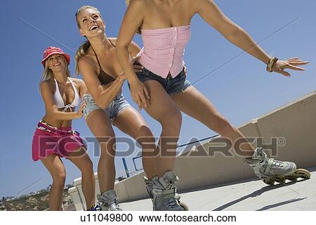 Stock Image - Young women on rollerblaeds. Fotosearch