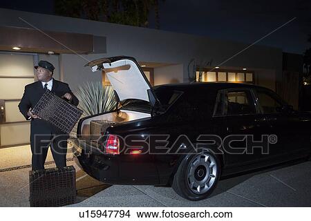 お抱え運転手 荷を積む スーツケース に 贅沢な車 夜で ピクチャー U Fotosearch